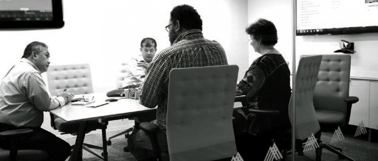 A group of people sitting at a conference table. 
