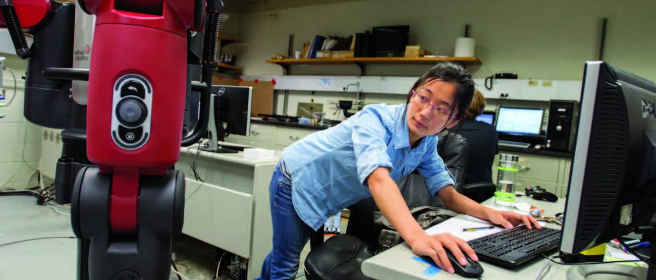 Woman working with robotic equipment.