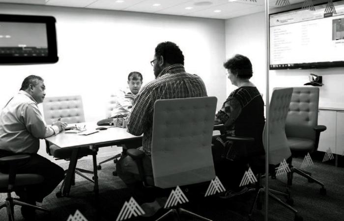 A group of people sitting at a conference table. 